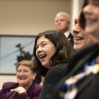 A daughter of an SES laughs at a joke during a swearing-in ceremony