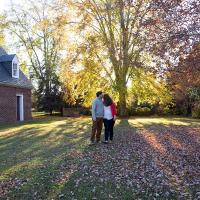 Newly engaged couple posing for a picture under a tree