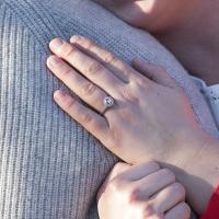 Newly engaged couple posing for a picture showing off engagement ring