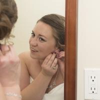 Bride getting ready for her wedding by putting earrings on