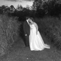 Newly wedded couple posing for a picture in a field