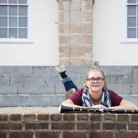 Young female posing for senior picture on location on stomach