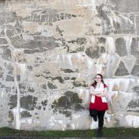 Young female posing for senior picture on location against rock wall